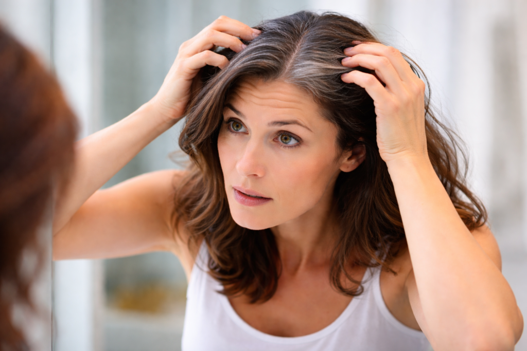 Grey hair strands appearing at the scalp during early ageing